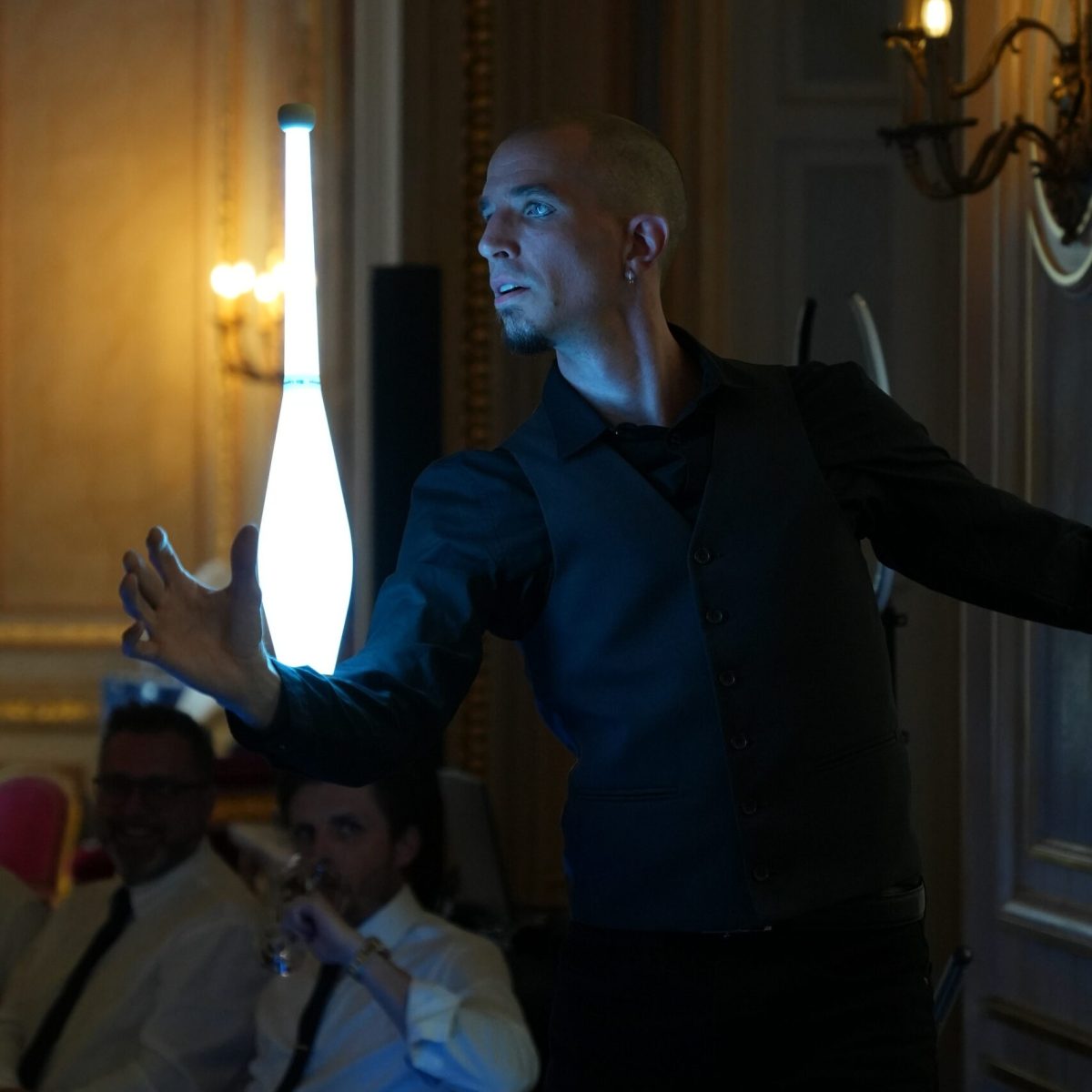 Massue lumineuse tenue en équilibre par un artiste pour une soirée privée au Palais Vivienne à Paris