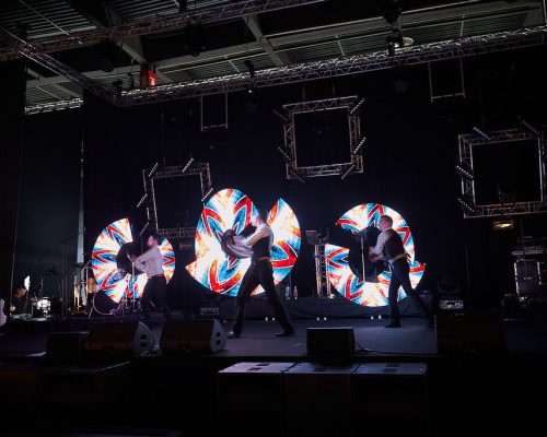 Trois artistes sur scène qui manipulent des pixel poi pour afficher des images lors de la soirée annuelle de Gédimat