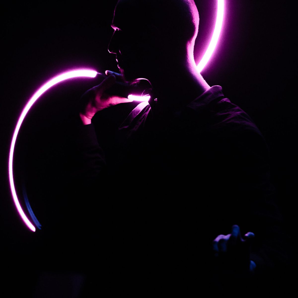Artiste de profil et dans la pénombre seulement illuminé par ses buugeng mauves