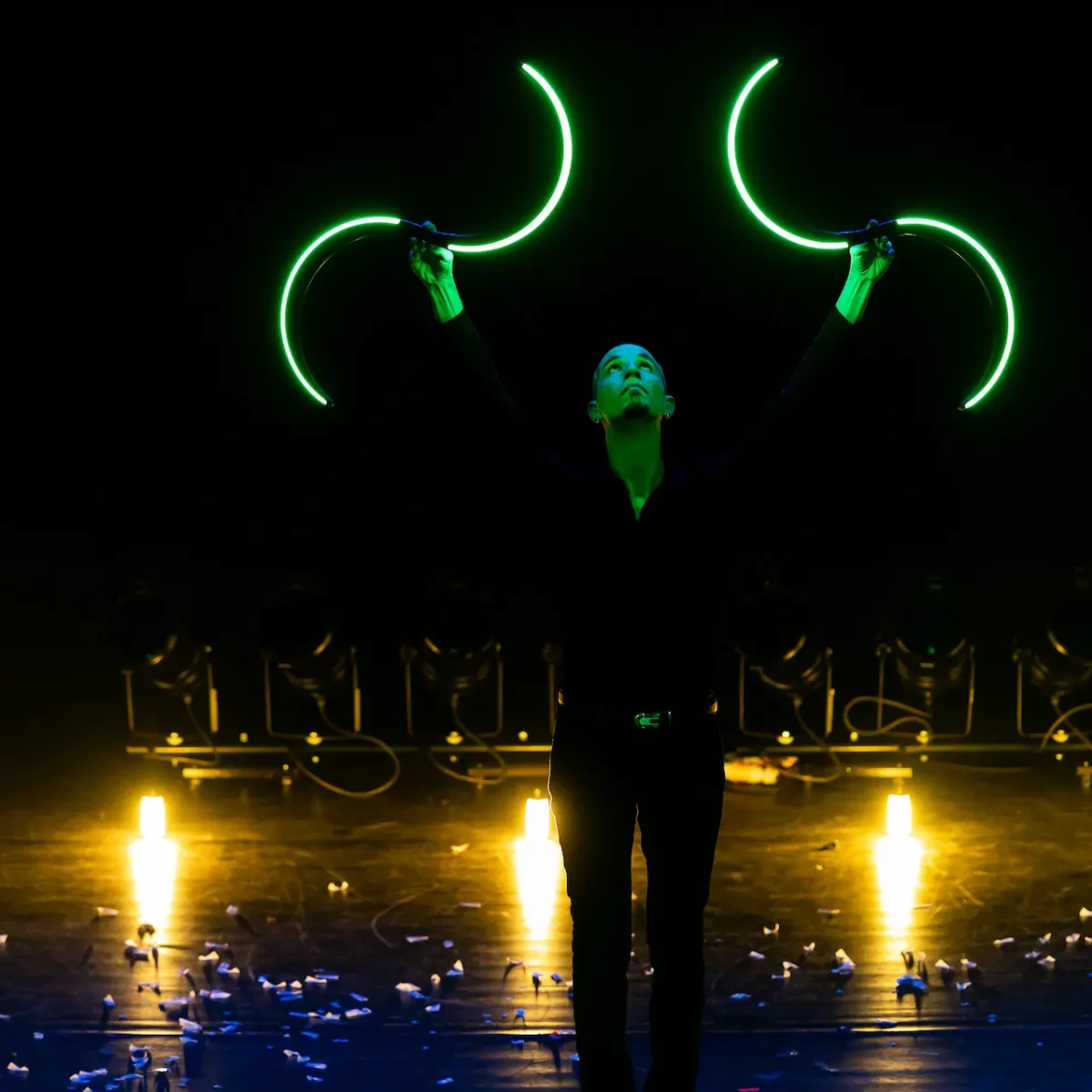 Un artiste en costume fait un show de buugeng LED en forme de S pour un mariage.