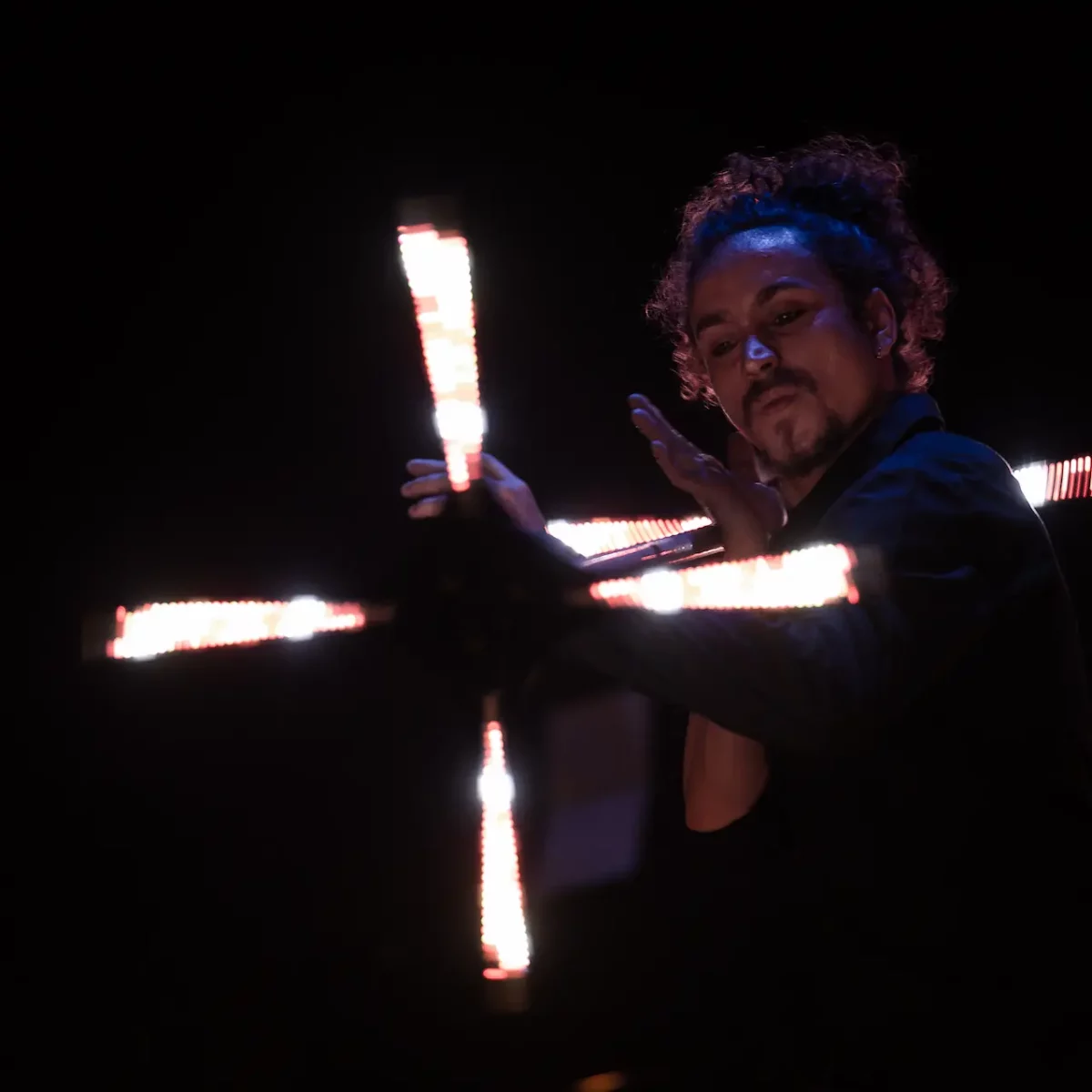 Un jongleur lumineux qui fait tourner un dragonstaff créant un effet lumineux qui affiche des images.