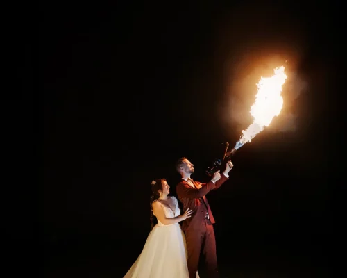 Photo du couple de mariés manipulant un lance-flamme pour leur photo souvenir de mariage.