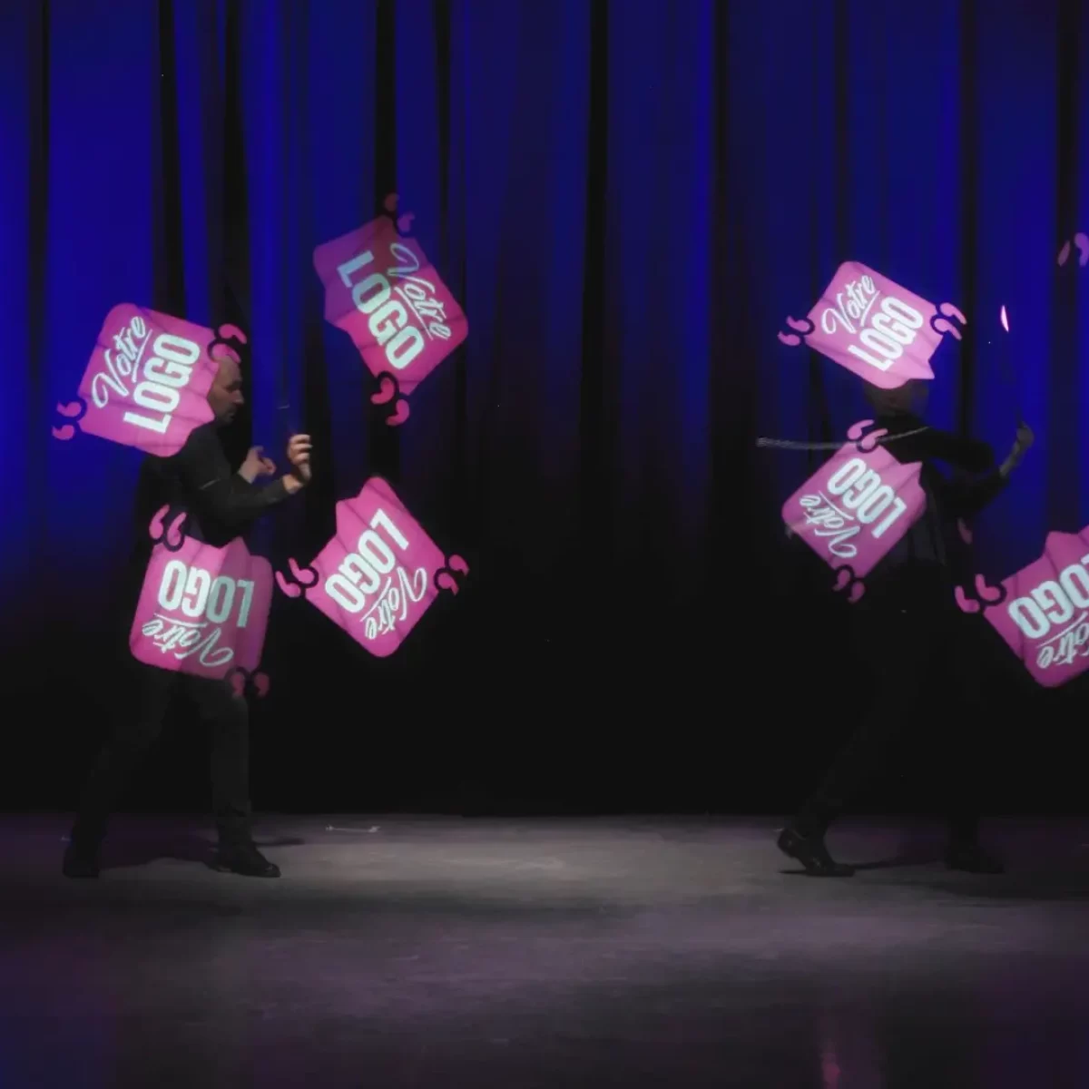 Performance de jonglerie LED graphique avec logos personnalisés pour un dîner de gala corporate.