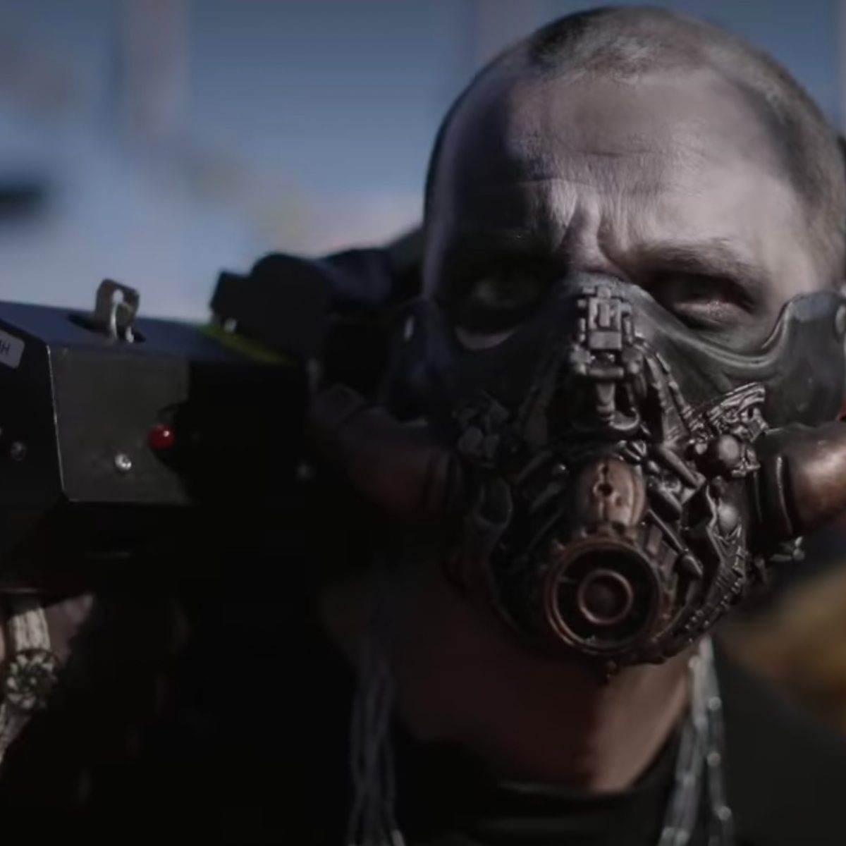 Personnage de Mad Max avec un masque et un lance-flamme